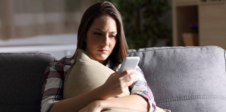 sad woman on the phone sitting on couch