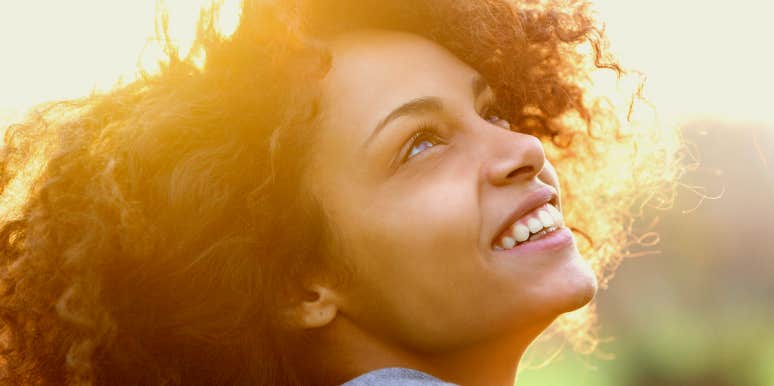 Clairaudience Young woman smiling and looking toward the sky.