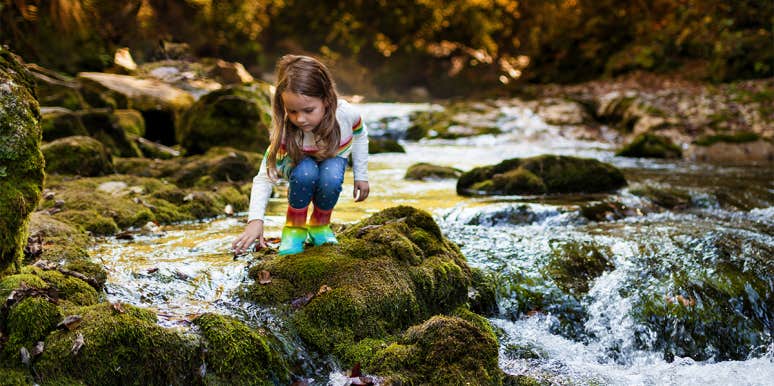little girl playing in stream