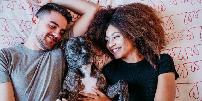How To Prepare For Getting A Dog Or Cat With Your Boyfriend Or Girlfriend couple with dog in bed