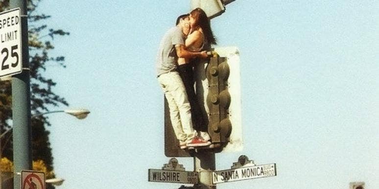 couple kissing street sign