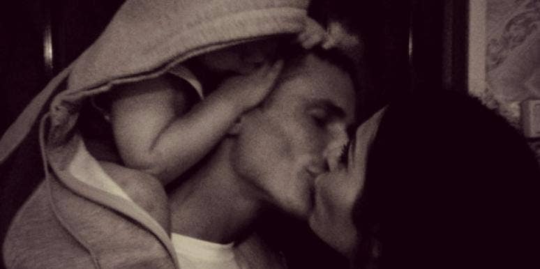 couple kissing with baby couple kissing with baby