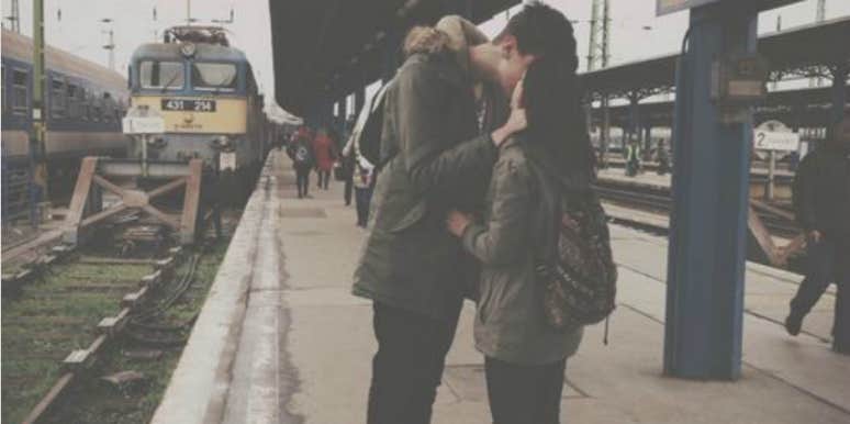 couple kissing next to train couple kissing next to train