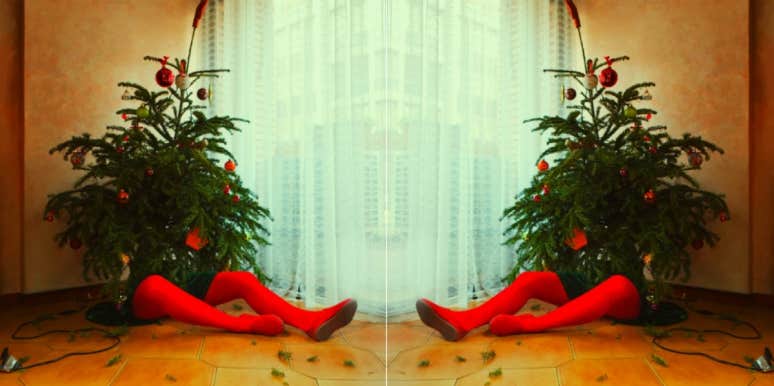 10 Creepy Christmas Songs That Are Actually Pretty Scary person sitting behind a Christmas tree