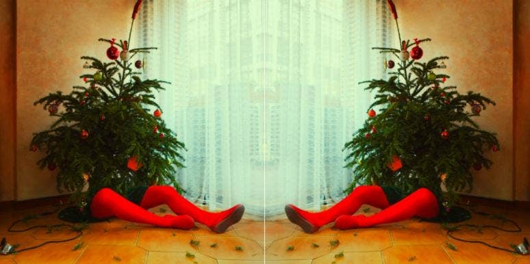 10 Creepy Christmas Songs That Are Actually Pretty Scary person sitting behind a christmas tree