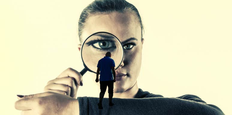 How To Know If Criticism Is Damaging Your Relationship (And What To Do If It Is) woman peering discerningly through magnifying glass at miniature defeated-looking man