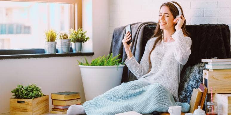 daily rituals woman wearing headphones covered in blanket at home