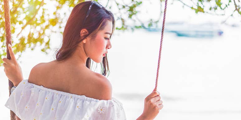 Here’s The Difference Between Being In Love And Just Missing Someone woman sitting on swing