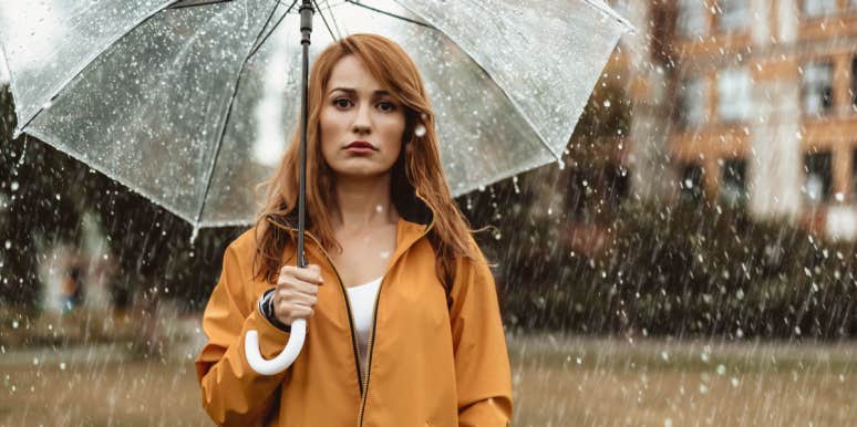 sad woman under umbrella