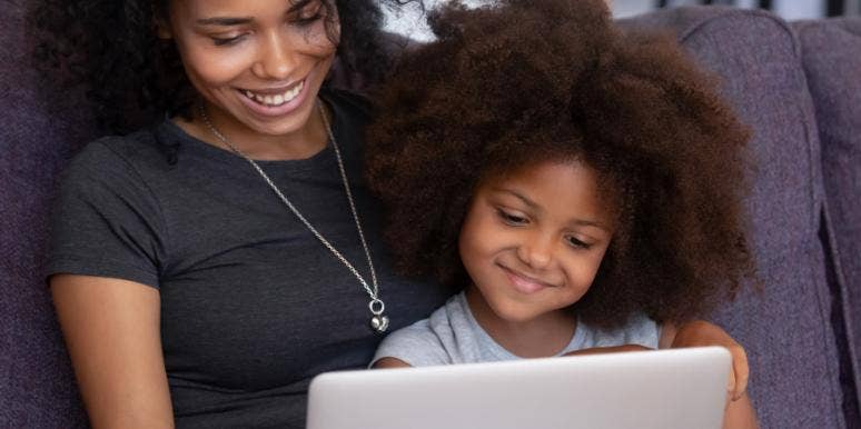 mom and young daughter looking at a laptop screen