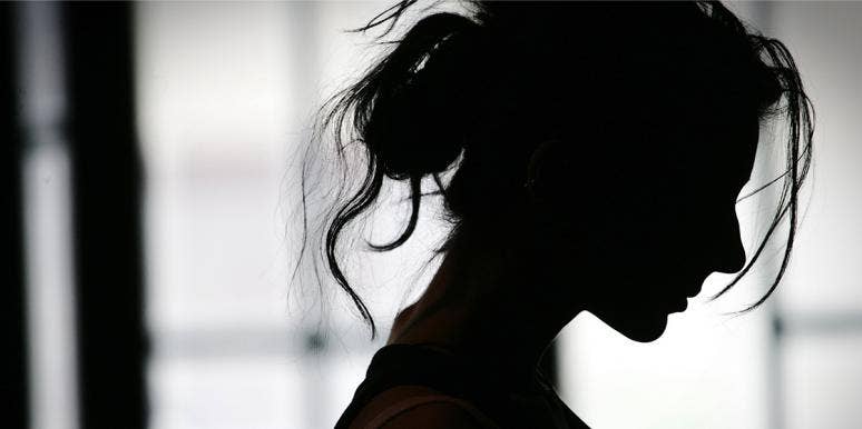 If He Engages In These 12 Behaviors, You're Being Emotionally Abused woman in shadow profile