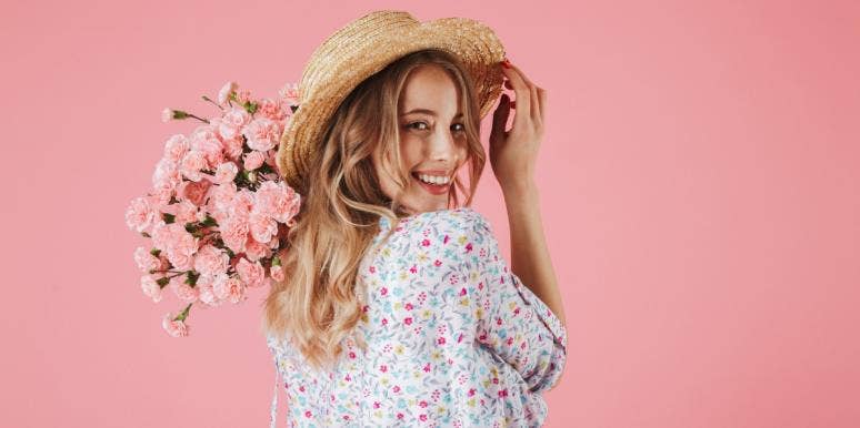 What It Means To Be An Eternal Optimist & How To Love One smiling woman holding flowers