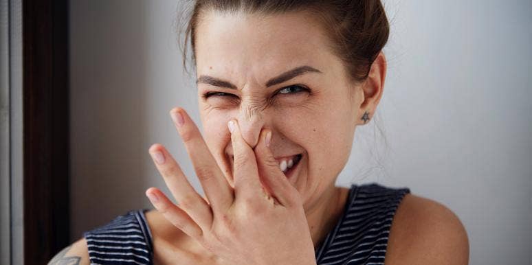 Can Smelling Farts Prevent Cancer? woman covering nose
