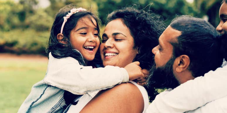 Conflict styles that harm kids when parents fight Dad, mom and young daughter hugging while laughing and talking