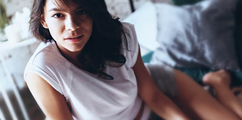 woman looks concerned while lounging in tee shirt and shorts