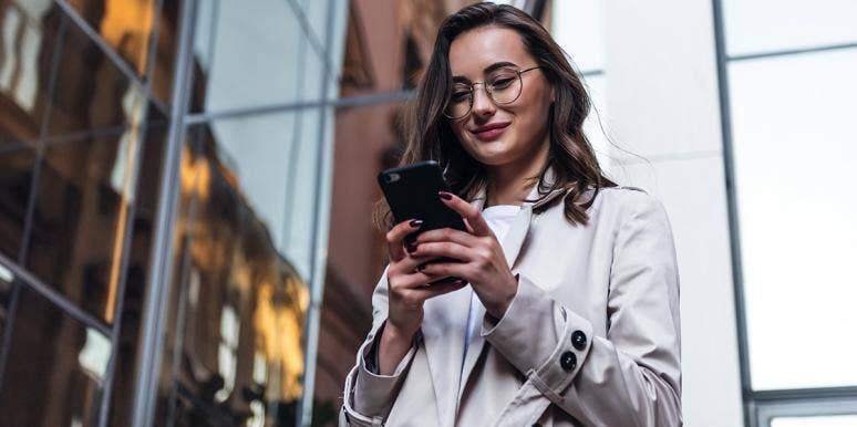 I Follow My Exes On Social Media, Even Though I'm Happily Married smiling woman on phone