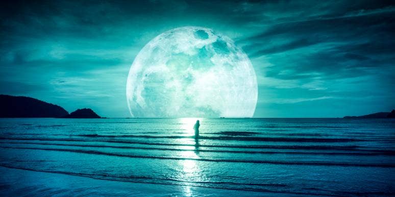 3 Zodiac Signs Whose Bad Luck Ends After The Full Moon In Capricorn, June 24th 2021 woman standing in front of a moon by water