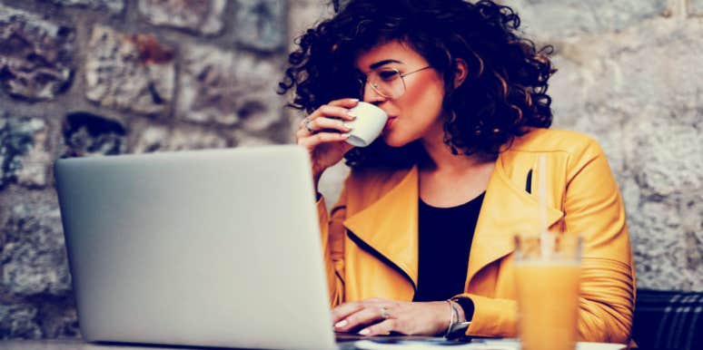 woman drinking espresso looking at computer choosing wifi names