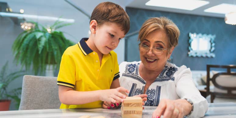 Woman Says Her Mom Will Not Babysit Her Grandkid Unless She's Paid $20/Hour Because She's 'Already Raised Her Own Kids' elderly woman and young boy assembling wooden blocks
