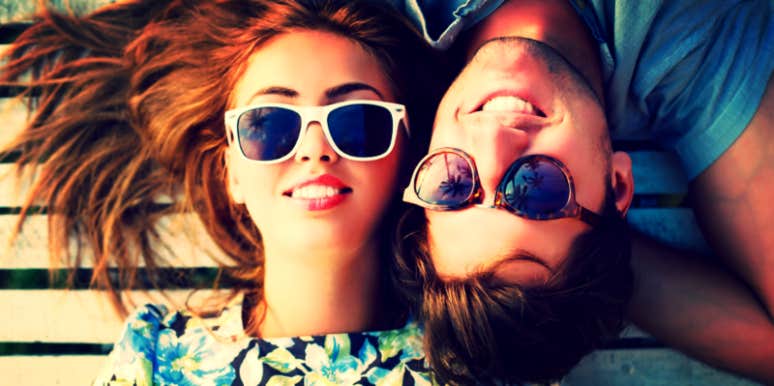 Guy and girl in sunglasses laying down