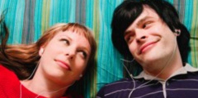 Is Your Male Friend Sabotaging Your Love Life? guy and girl laying on blanket listing to headphones