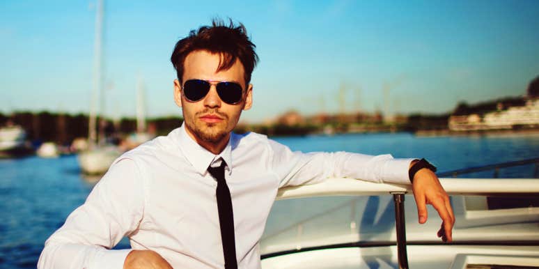 fancy young white man on boat wearing tie and sunglasses