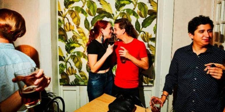 man and woman kissing at a party