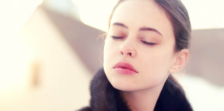 young white woman with brown hair closes her eyes, pensive