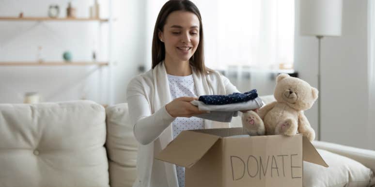 woman packs box with clothes and toys to donate to kids