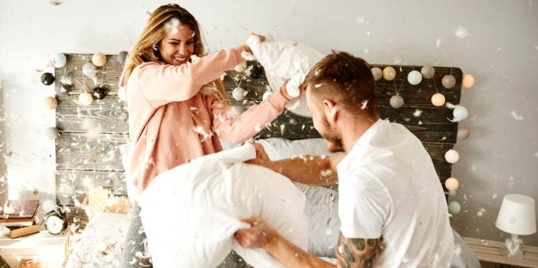 man and woman pillow fighting