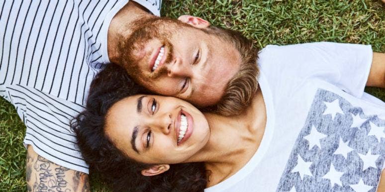 Man falling in love with woman laying down on grass
