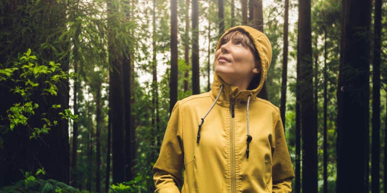 woman in yellow raincoat walking through the Redwood forest 