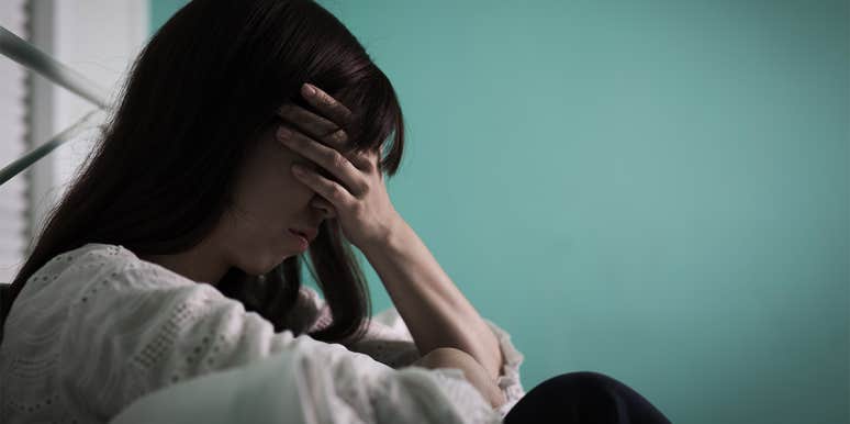 How To Know If You Have A 'Father Wound' — And If It Still Affects You Today sad woman covering face
