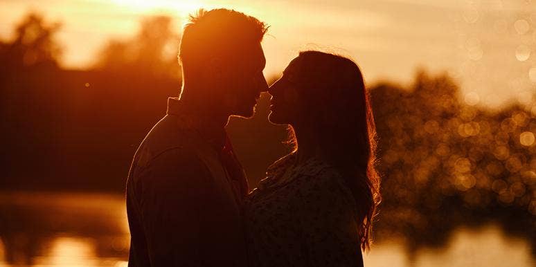 man and woman hugging at sunset 
