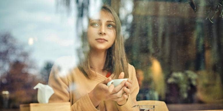 woman drinking coffee in window