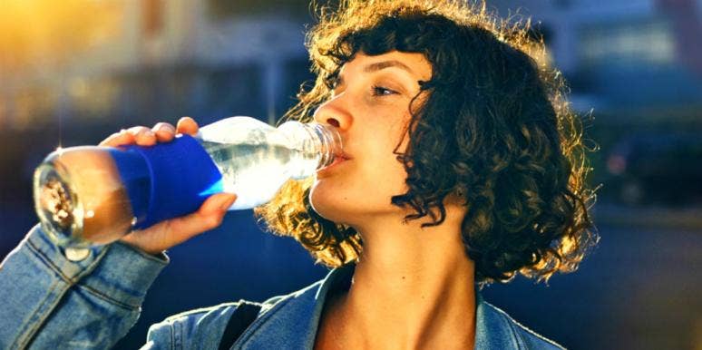 woman drinking from a bottle of water