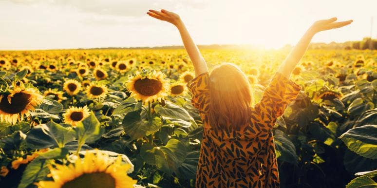 4 Research-Backed Strategies That Will Help You Feel Instantly Happier woman in sunflower field