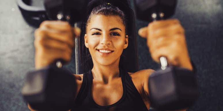 woman smiles while lifting 5 lb. weights 