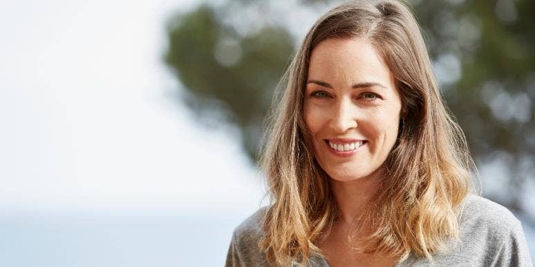 How To Be Less Judgmental Of People You Disagree With smiling woman on a beach