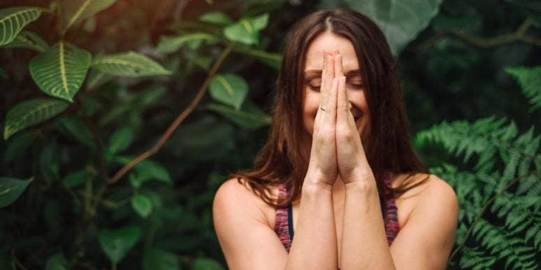 how to be original woman meditating with green behind her