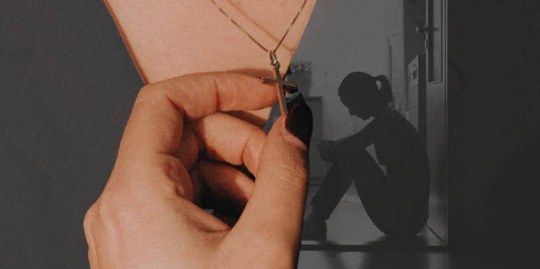 Woman holding onto cross necklace 