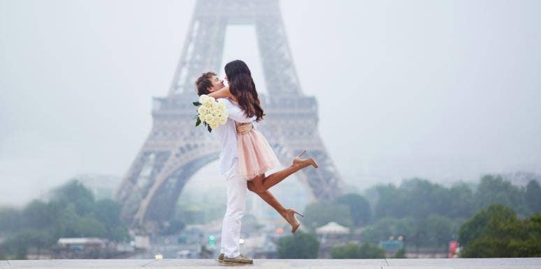 man and woman hugging in front of Eiffel Tower