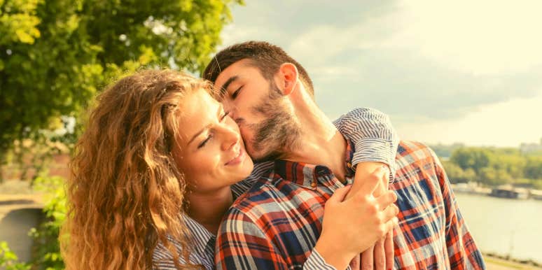 How To Get Into A Guy's Head And Make Him Crazy About You woman hugging man while he turns around to kiss her