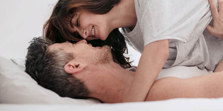 man and woman kissing in bed
