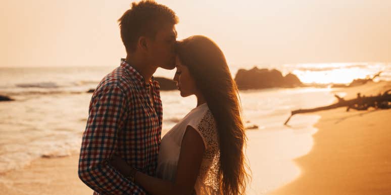 5 Simple Ways To Make Him Want To Commit To You man kissing woman's forehead on beach