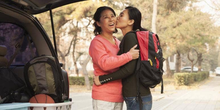 young adult child going to college kissing mom on cheek