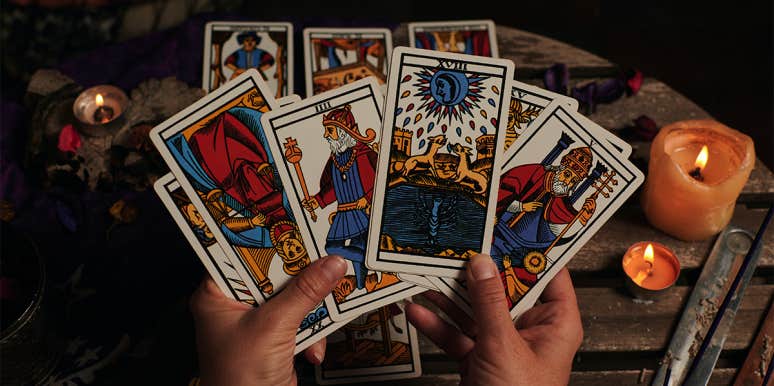 How To Read Tarot Cards: Tips For Beginners person holding tarot cards