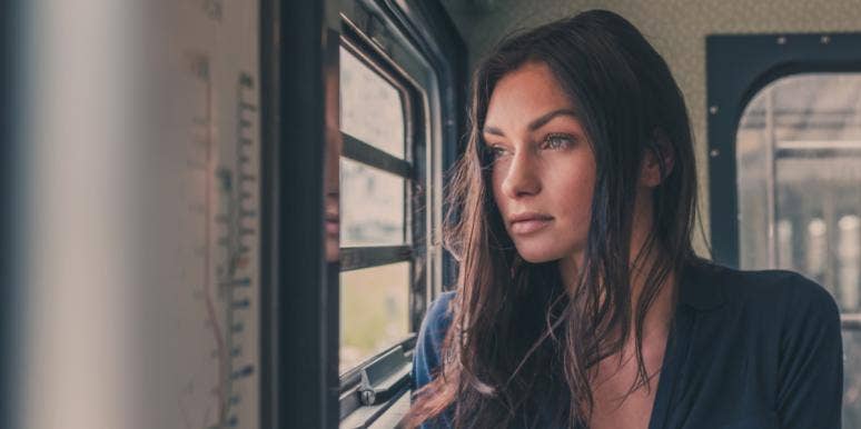sad woman on train looking out window