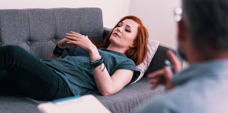 woman laying on couch with hands folded on top of her