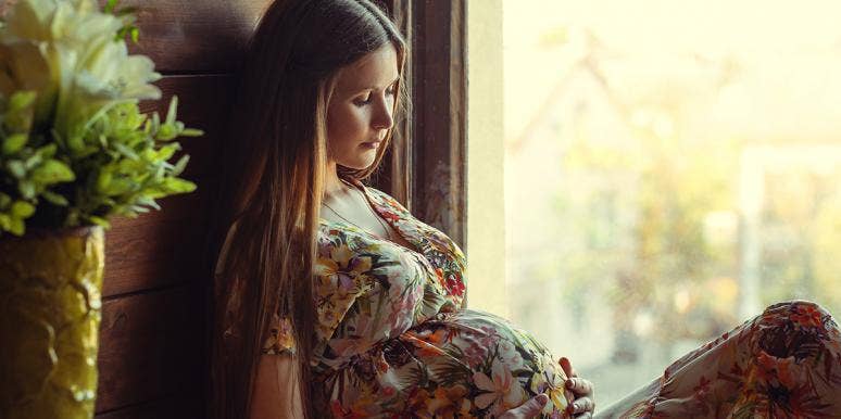 I Hypnotized Myself While Giving Birth And It Was The Best Thing I've Ever Done woman cradling pregnant belly